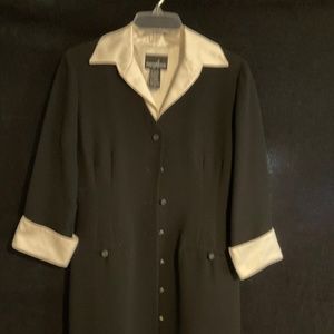 Full length dress, black with white cuffs and collar. Buttons from top to botto.